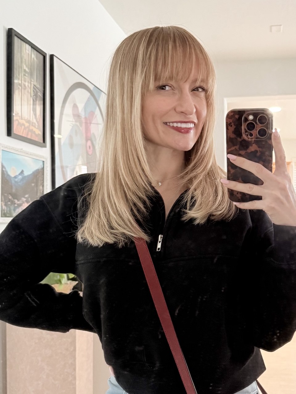 Hannah Stark, the home & lifestyle creator behind With Style Hannah, smiling in a room with a gallery wall.